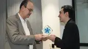 El padre Vicente Durán Casas, SJ, entrega a Santiago Valencia, estudiante de Derecho, el premio al Mejor estudiante de Consultorio Jurídico 2025